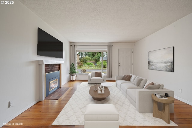 10438 NE Davis St, Portland, OR 97220 - living area featuring wood finished floors, a textured ceiling, a tile fireplace, and baseboards