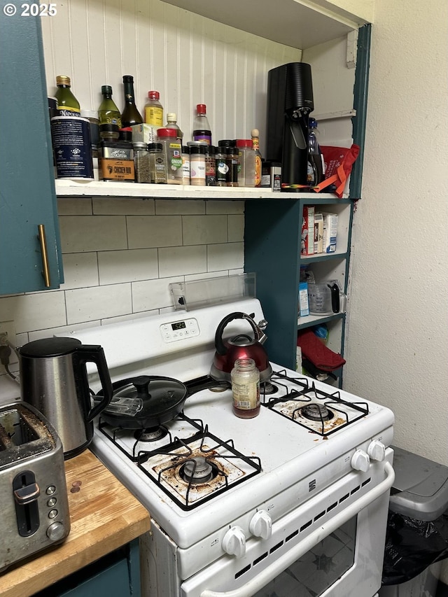 2126 SE 162nd Ave, Portland, OR 97233 - kitchen with white gas stove, decorative backsplash, and butcher block countertops