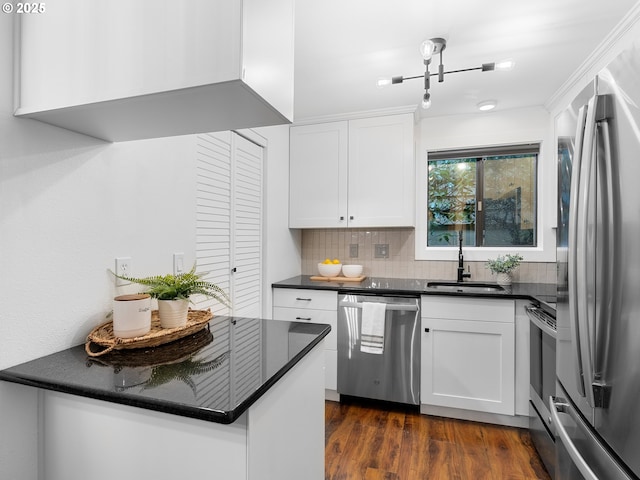 kitchen featuring appliances with stainless steel finishes, dark hardwood / wood-style flooring, backsplash, sink, and white cabinetry