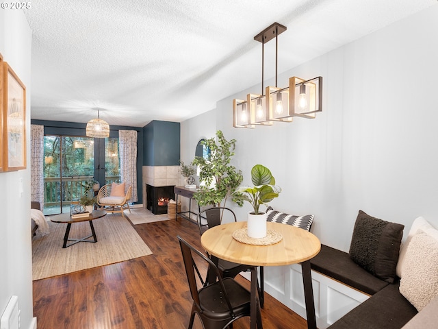 dining area with a textured ceiling and dark hardwood / wood-style floors