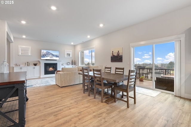 16679 SW Darwin Loop, Portland, OR 97224 - dining space featuring light wood-style floors, a glass covered fireplace, and recessed lighting