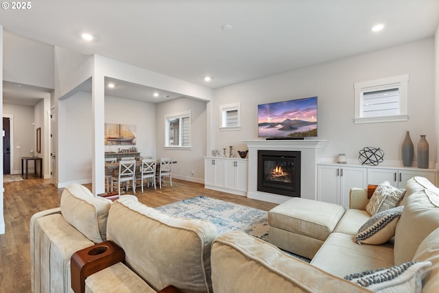 16679 SW Darwin Loop, Portland, OR 97224 - living room featuring wood finished floors, a glass covered fireplace, baseboards, and recessed lighting