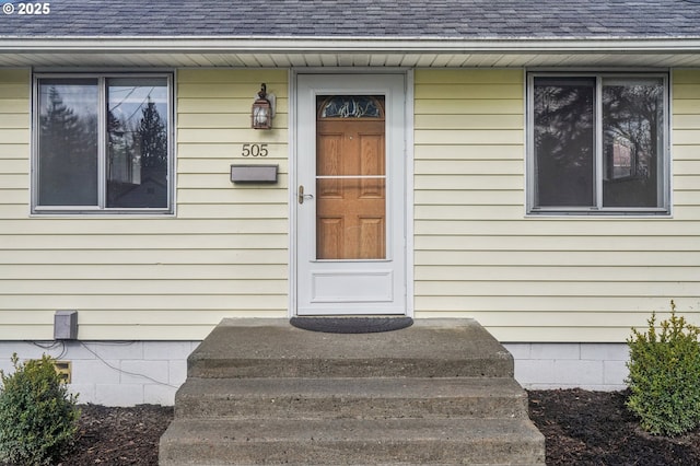 doorway to property with roof with shingles