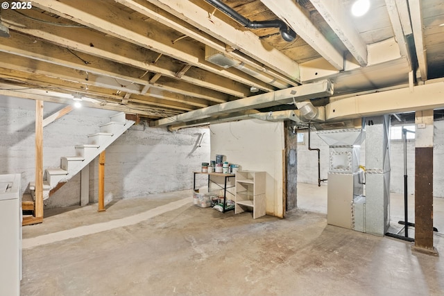 below grade area featuring heating unit and washer / dryer