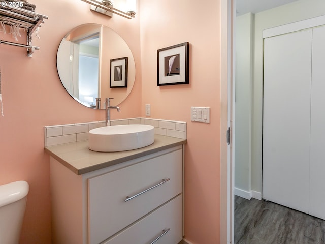12600 SW Crescent St Unit 213, Beaverton, OR 97005 - bathroom with wood finished floors, vanity, toilet, and backsplash