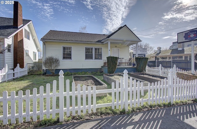 view of front facade with a garden, a fenced front yard, and a front lawn