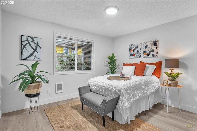 bedroom featuring wood-type flooring and a textured ceiling