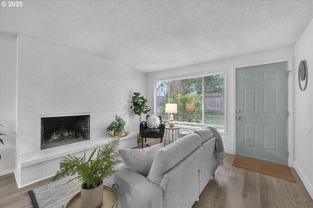 living room with a fireplace, wood-type flooring, and a textured ceiling