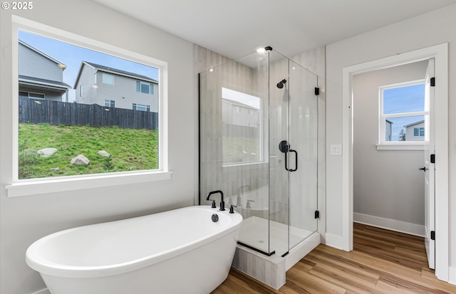 8728 S 4th Way, Ridgefield, WA 98642 - bathroom featuring a freestanding bath, a shower stall, wood finished floors, and baseboards