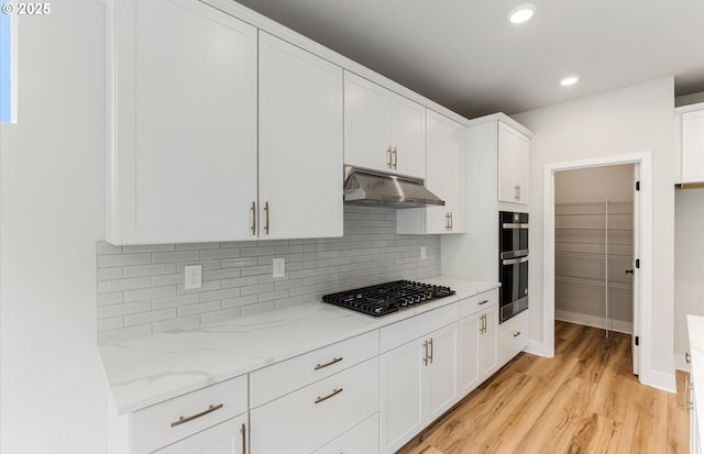 8728 S 4th Way, Ridgefield, WA 98642 - kitchen featuring appliances with stainless steel finishes, under cabinet range hood, backsplash, white cabinetry, and light wood-style flooring