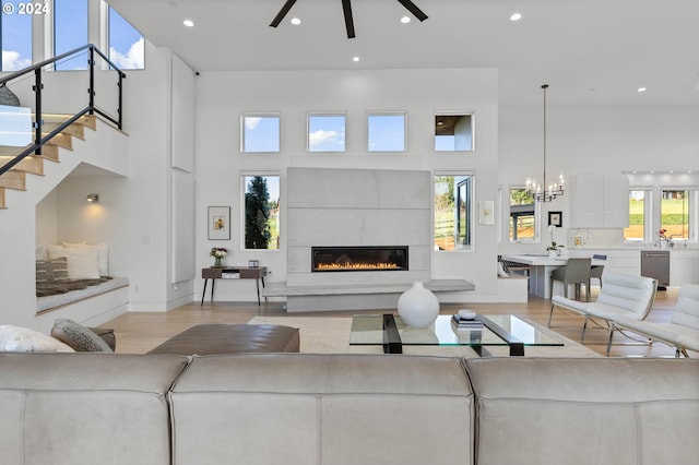 living area featuring recessed lighting, wood finished floors, a towering ceiling, and a fireplace