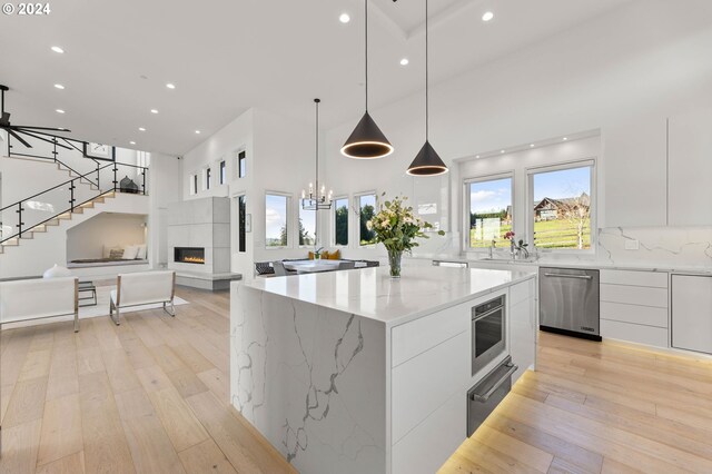 kitchen with a fireplace, white cabinets, dishwasher, a warming drawer, and modern cabinets