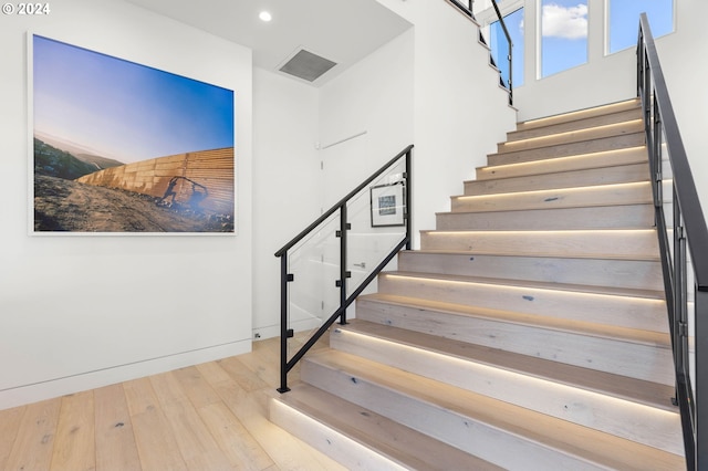 stairway with hardwood / wood-style floors, recessed lighting, visible vents, and baseboards