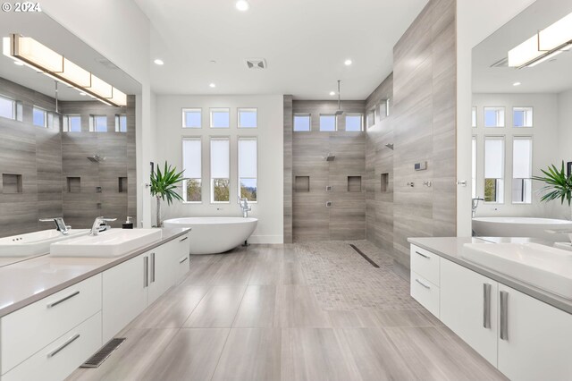 bathroom featuring visible vents, a walk in shower, recessed lighting, a soaking tub, and vanity