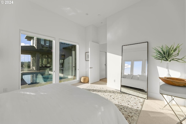 bedroom featuring multiple windows and a high ceiling