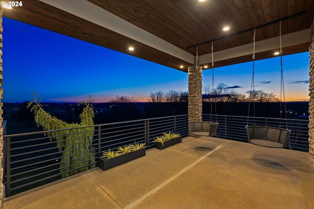 patio terrace at dusk featuring a balcony