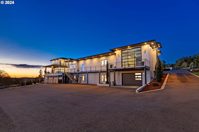 view of front of home featuring stucco siding, an attached garage, and stairs