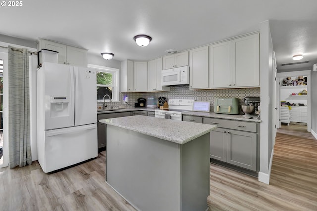 1533 Sequoia Ave, Springfield, OR 97477 - kitchen featuring white appliances, a sink, light wood-type flooring, tasteful backsplash, and a kitchen island