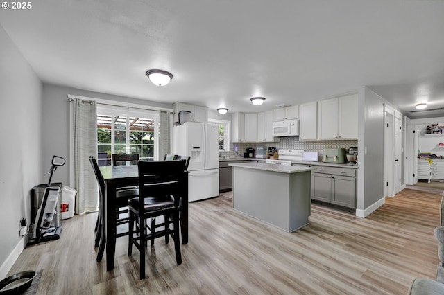 1533 Sequoia Ave, Springfield, OR 97477 - kitchen with white appliances, light wood-style floors, gray cabinetry, a center island, and baseboards