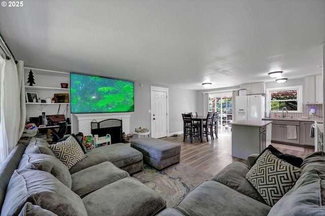 1533 Sequoia Ave, Springfield, OR 97477 - living area featuring light wood-type flooring, a brick fireplace, and baseboards