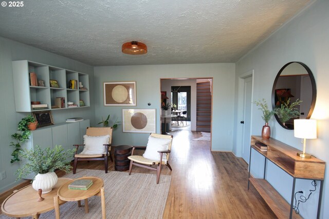 living area with hardwood / wood-style flooring and a textured ceiling