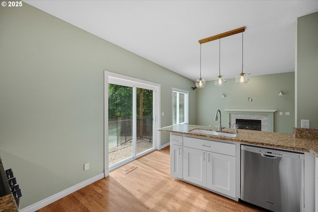 5966 Frost Ln, Lake Oswego, OR 97035 - kitchen featuring stainless steel dishwasher, white cabinets, light wood-type flooring, a fireplace, and a peninsula