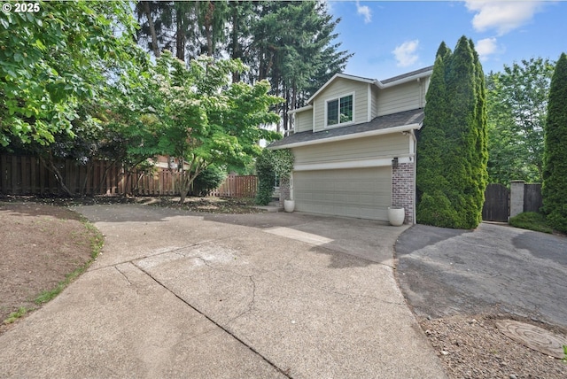5966 Frost Ln, Lake Oswego, OR 97035 - view of side of property featuring concrete driveway, brick siding, an attached garage, and a gate