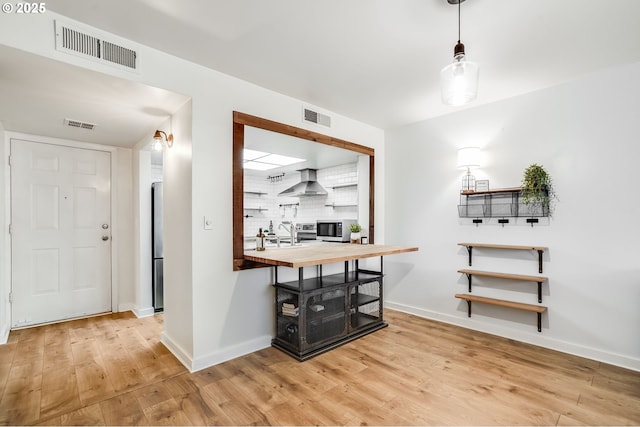 dining area featuring wood finished floors, visible vents, and baseboards