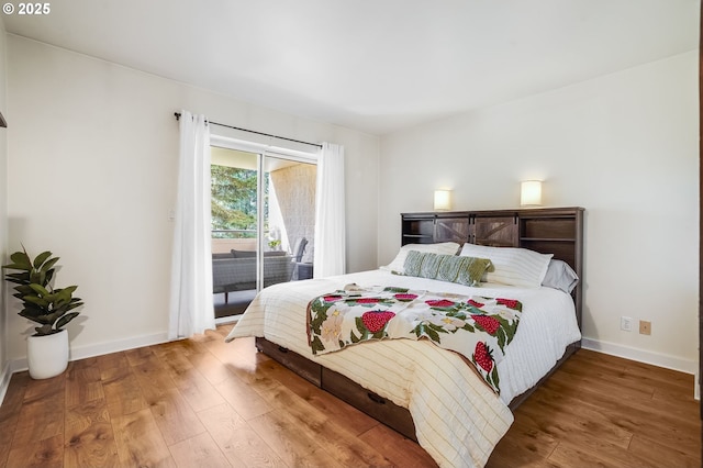 bedroom with baseboards, access to exterior, and hardwood / wood-style floors