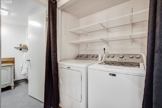 clothes washing area featuring washing machine and dryer, laundry area, and light tile patterned floors
