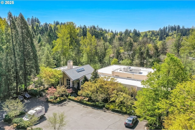 drone / aerial view featuring a wooded view