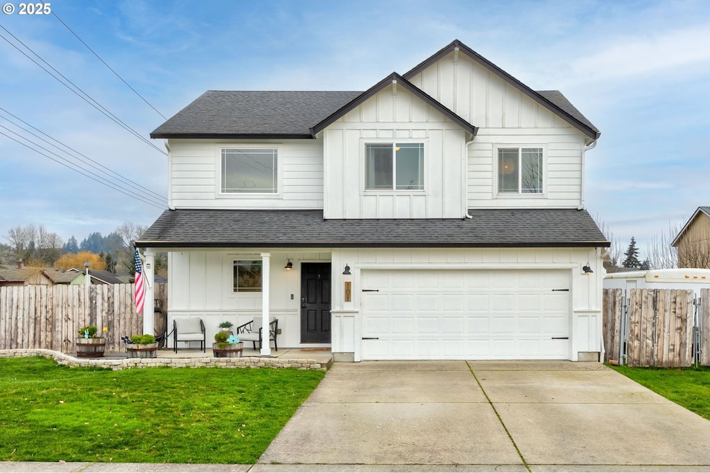 view of front of home featuring a front yard, a garage, and covered porch