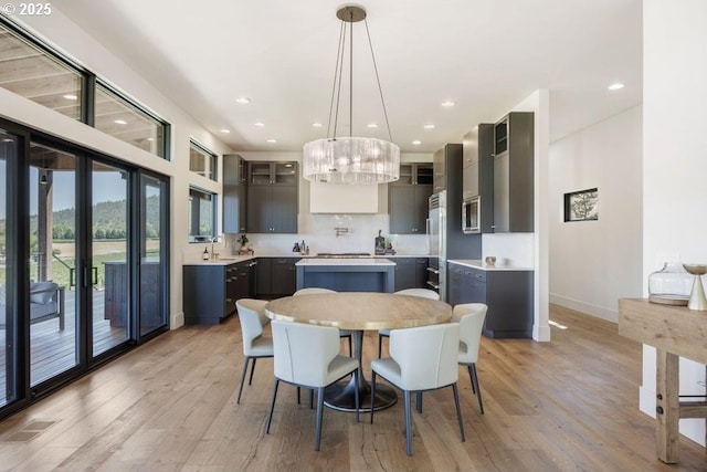 dining space featuring sink, light hardwood / wood-style floors, and a notable chandelier