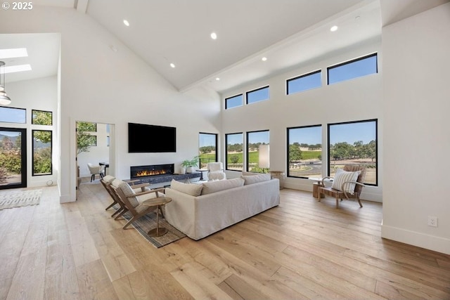 living room with light wood-type flooring and a towering ceiling