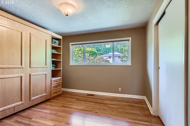 7145 SW Gable Pkwy, Portland, OR 97225 - unfurnished bedroom featuring light wood-type flooring, a closet, and a textured ceiling
