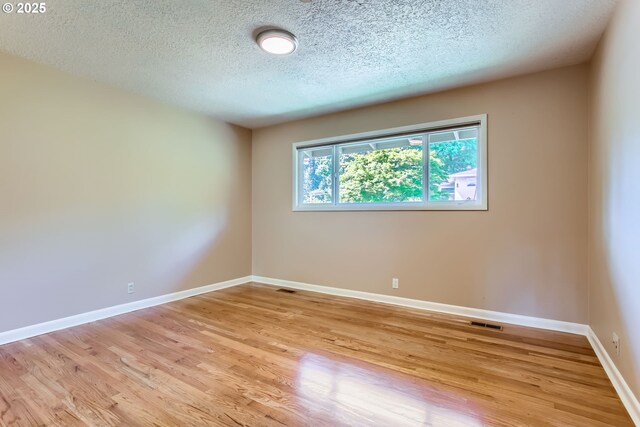 7145 SW Gable Pkwy, Portland, OR 97225 - empty room with a textured ceiling and light wood-style flooring