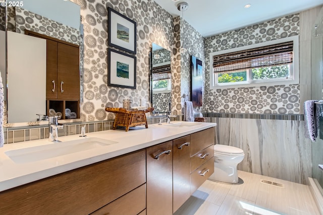7145 SW Gable Pkwy, Portland, OR 97225 - bathroom featuring wallpapered walls, double vanity, a wainscoted wall, and tile walls