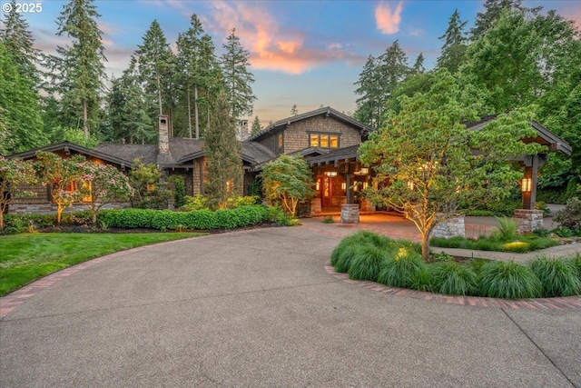 13150 SW Iron Mountain Blvd, Portland, OR 97219 - view of front facade featuring curved driveway, stone siding, and a chimney