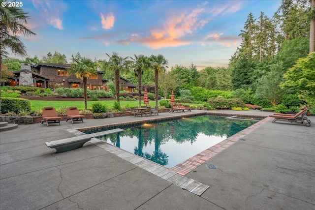 13150 SW Iron Mountain Blvd, Portland, OR 97219 - pool at dusk with a patio area, a diving board, and an outdoor pool