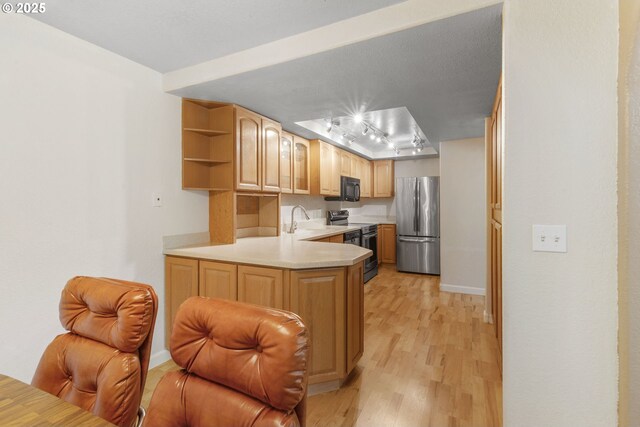 1621 NE 113th St Unit 132, Vancouver, WA 98686 - kitchen with stainless steel appliances, light wood-style floors, light countertops, rail lighting, and a peninsula