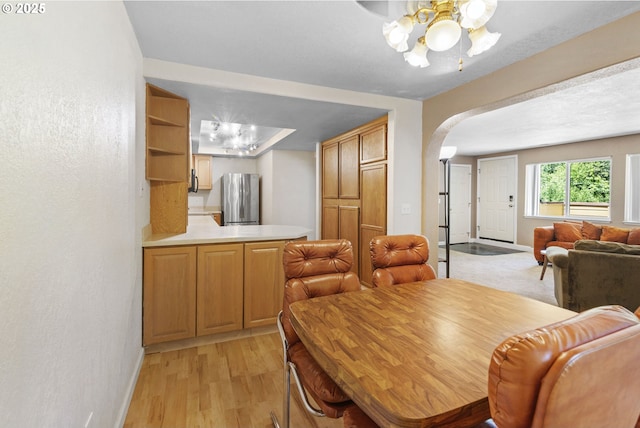 1621 NE 113th St Unit 132, Vancouver, WA 98686 - dining space featuring arched walkways, a ceiling fan, light wood-type flooring, and baseboards