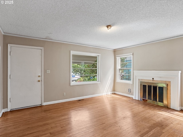 4315 SE 28th Pl, Portland, OR 97202 - unfurnished living room with crown molding, wood finished floors, a textured ceiling, baseboards, and a tile fireplace
