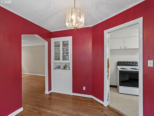 4315 SE 28th Pl, Portland, OR 97202 - unfurnished dining area with a chandelier, a textured ceiling, wood finished floors, ornamental molding, and baseboards