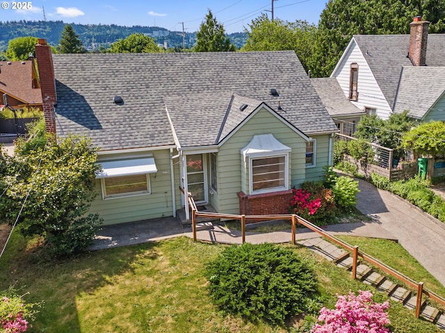 4315 SE 28th Pl, Portland, OR 97202 - view of front of home with a chimney, a front lawn, a patio area, and roof with shingles