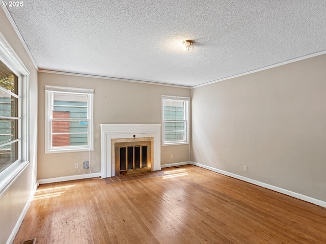 4315 SE 28th Pl, Portland, OR 97202 - unfurnished living room with hardwood / wood-style flooring, a textured ceiling, a fireplace, crown molding, and baseboards