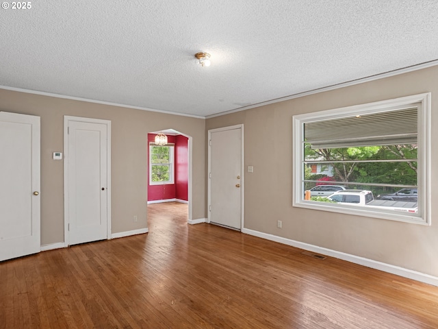 4315 SE 28th Pl, Portland, OR 97202 - foyer entrance with arched walkways, wood finished floors, a textured ceiling, ornamental molding, and baseboards