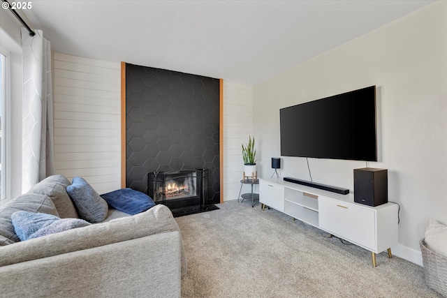 carpeted living room featuring a healthy amount of sunlight, a fireplace, and wood walls