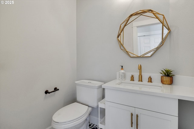 half bathroom featuring toilet, baseboards, and vanity