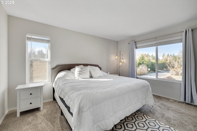 bedroom featuring light carpet, multiple windows, and visible vents