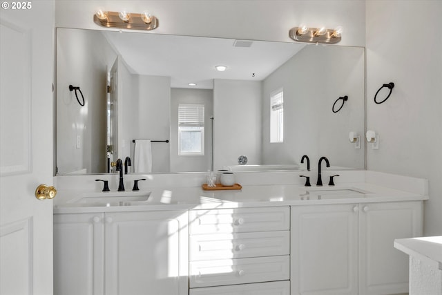 full bath featuring double vanity, a sink, and visible vents